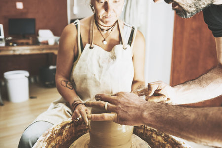 Make more art, have more fun. a young man and woman working with clay in a pottery studio.の写真素材