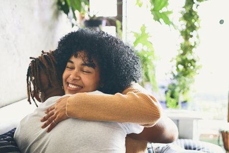 Love makes your soul crawl out from its hiding place. a young woman hugging her boyfriend at home.の写真素材