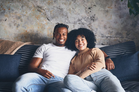 Were 100 not leaving the house today. Portrait of a young couple relaxing together on a sofa at home.の写真素材