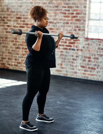 Be stronger than your excuses. a young woman working out in a gym.の写真素材