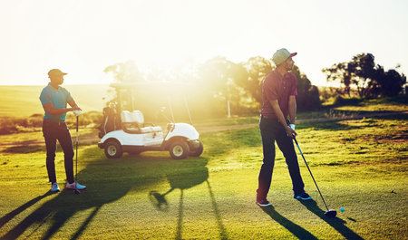 Lifes a pitch, and then you putt. two friends playing a round of golf out on a golf course.の写真素材