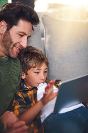 Browsing with my boy. a handsome young father and his adorable little son using a tablet together on...