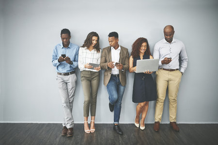 Go wireless to browse wherever you are. Studio shot of a group of businesspeople using their...