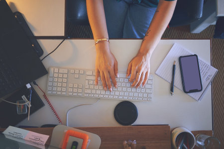 Never stop setting goals for yourself. High angle shot of an unrecognizable woman sitting alone and using her computer to work from home.の写真素材