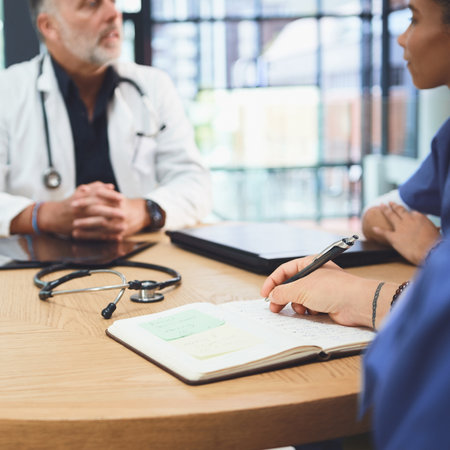 Taking note of important info. Closeup shot of a doctor writing notes during a meeting with colleagues in a hospital.の写真素材