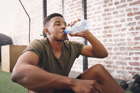 The one thing we cant live without is water. a sporty young man drinking a bottle of water at the...