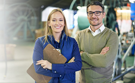 Together, they have this factory running smoothly. Portrait of a two smiling managers standing on...