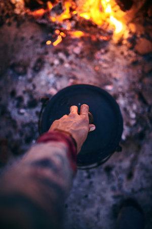 A tasty surprise awaits. a man cooking traditional South African food by campfire outdoors.の写真素材