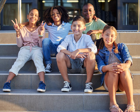 School, friends and children sitting on steps smiling, happy and excited for learning, class and lesson. Education, back to school and portrait of young students in primary school ready for knowledgeの写真素材