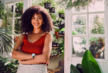 Black woman, arms crossed or plant shop worker and agriculture knowledge, carbon footprint innovation or growth ideas. Portrait, smile or happy florist, garden center employee or small business ownerの写真素材