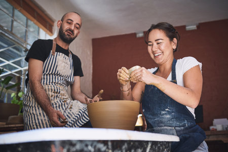 Turn your feelings into something tangible. a young man and woman working with clay in a pottery studio.の写真素材