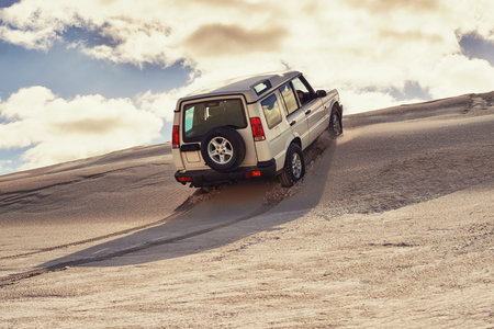 Taking on the dunes. a heavy duty 4x4 driving along some sand dunes.