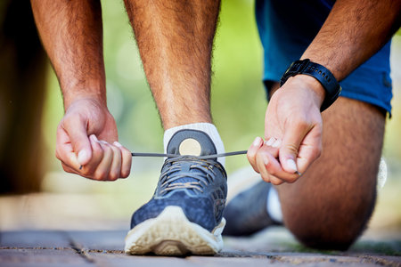 Fitness, running and man tie shoes for exercise, marathon training and cardio workout in outdoor park. Sports, performance and zoom of runner with sneakers lace for wellness, healthy body and jogの写真素材