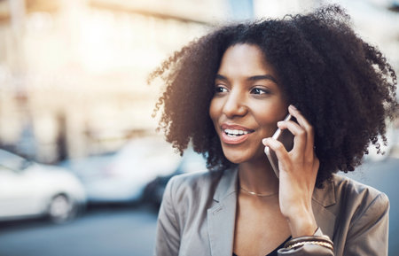 Business woman, phone call and city for conversation, communication or networking outdoors. Female employee talking on mobile smartphone with smile for discussion in the street of an urban townの写真素材