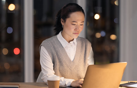 Overtime, email and business woman on a laptop, typing and planning on the internet in a dark office. Corporate, strategy and Asian employee working on the web for a deadline on a pc at nightの写真素材