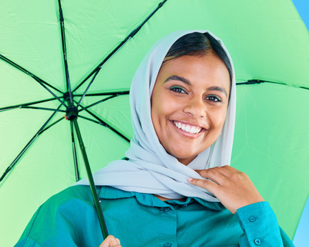 Fashion portrait, Muslim and happy woman with umbrella, designer brand clothes or casual outfit style. Trendy gen z winter aesthetic, beauty smile and face of Arabic Islamic female in studioの写真素材