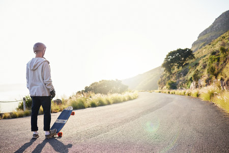 Skateboard, mountain and man in road for sports competition, training and exercise in urban city. Skating mockup, thinking and male skater standing in street for challenge, adventure and freedomの写真素材