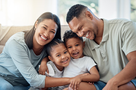 Happy, love and family portrait with kids, parents and relax on a sofa with a smile in the living room. Happiness, care and mom with dad sitting and holding children with joy on a couch in home.の写真素材