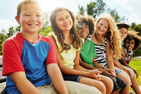 Cheerful childhood days. Portrait of a group of diverse and happy kids hanging out together outside.
