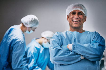 Theatre, portrait and man doctor with arms crossed for hospital teamwork, leadership and medical surgery. Happy surgeon or healthcare person in operating room or theater for emergency and solutionの写真素材