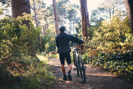 Nature, fitness and man cyclist with a bicycle for cardio training, health or wellness in the woods....