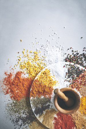 Only the finest will do. a pestle and mortar with an assortment of spices scattered around it.の写真素材