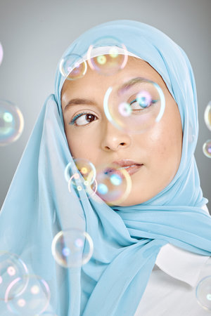 Skincare, bubbles and Muslim model with beauty, idea and thinking against a grey studio background....