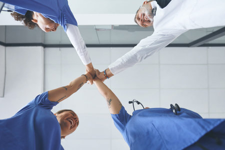 This win is for us. Low angle shot of a diverse group of healthcare professionals standing and...