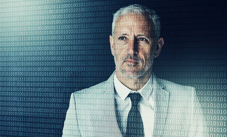 The computer age. a mature businessman working on programming code.の写真素材