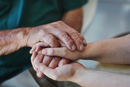 Too often we underestimate the power of a listening ear. Closeup shot of a woman holding a senior mans hands in comfort.の写真素材