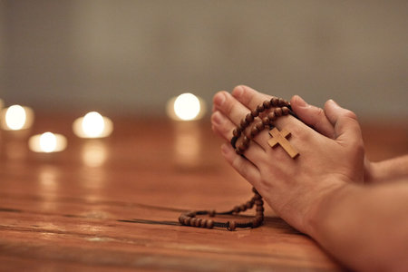 Prayer can change everything. Cropped shot of a man holding a rosary and praying.の写真素材