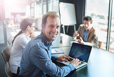 Happy, meeting and portrait of a businessman with a laptop for notes, email or planning at work....