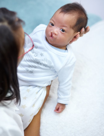Family, mother and a baby with a cleft lip in the bedroom of their home together for love or care from above. Healthcare, medical and female child with a disability in the arms of her mama in a houseの写真素材