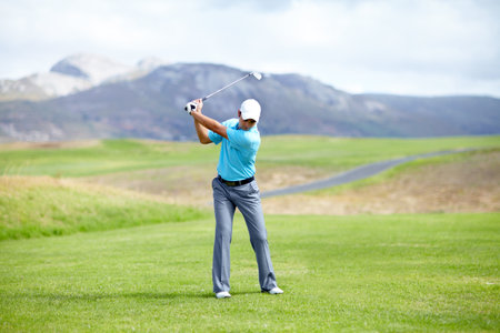Fitness, man or golfer playing golf for fitness, workout or exercise with a swing on a green course. Wellness, person golfing or athlete training in action or sports game driving with a club strokeの写真素材