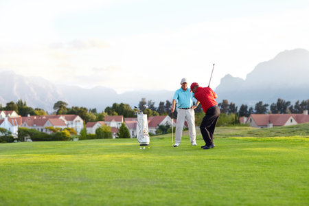 Golf course, stroke and training on the course, field or men in professional, golfer sports club and exercise on the grass. Friends, businessman or healthy game or competition on the green turfの写真素材