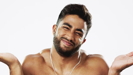 Uncertain confused and face of man in studio for wellness, skincare and hygiene on white background. Doubt, portrait and indian male model with unsure shrugged shoulders contemplating beauty cosmeticの写真素材