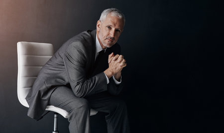 Im committed to my companys vision. Studio portrait of a mature businessman against a dark background.の写真素材