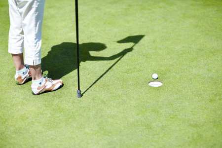 Flag, shoes or person playing golf for fitness, workout or exercise with ball shadow on a green...