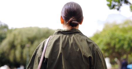 Back, walking and business woman at park for travel, journey and trip to work outdoor in the...