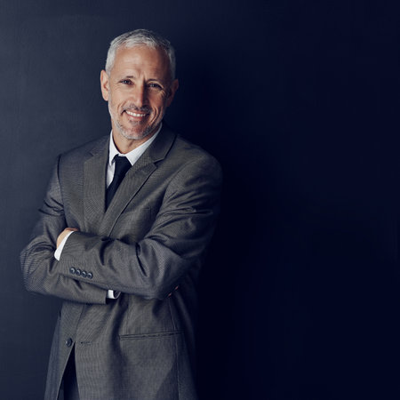 Smile, confidence and portrait of businessman in mockup, arms crossed and pride on dark background. Boss, ceo and happy business owner with professional career, senior model in suit in executive jobの写真素材