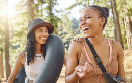 Women friends, camping and smile in woods, sunshine or funny chat on adventure, bonding and freedom on holiday. African girl, together and happy people for summer vacation, forrest and walk in natureの写真素材