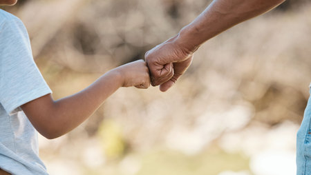 Support, love and father and child with fist bump for motivation, care and trust in nature. Family,...