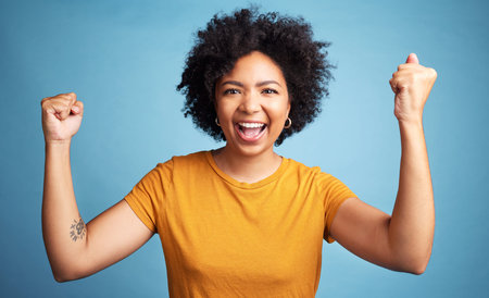 Winner portrait, yes and woman isolated on blue background in winning, success and news or college...