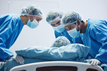 Surgery, mask and team of doctors working with patient, person in bed or operation in hospital with healthcare workers. Medicine, collaboration and trust in nurses, surgeon or people in clinicの写真素材