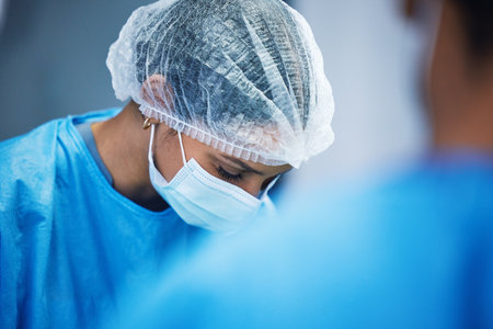 Hospital, surgery and team of doctors in theatre for medical support, teamwork or healthcare solution in face mask. Focus of nurses and surgeon in blue scrubs in operating room, emergency and helpingの写真素材