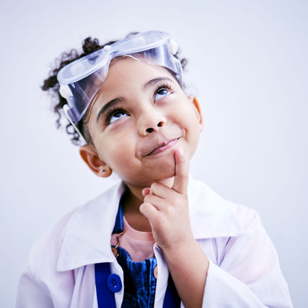 Child, thinking and face of scientist girl in studio with .hand on chin, goggles and idea. Happy African kid student with solution or problem solving medical science, education or biology experimentの写真素材