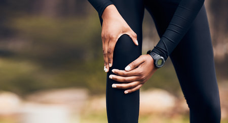 Knee pain, fitness and running person with medical injury, training or sports anatomy problem in forest or nature. Cardio, exercise or workout risk of runner, athlete or people in woods and legs zoomの写真素材