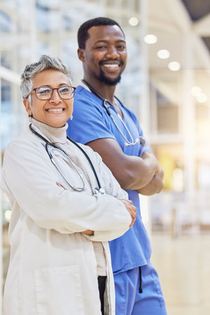 Doctor, together and portrait with cross arm and smile at hospital with medicine. Healthcare professional, team and senior female and man at clinic for support with collaboration for help or service.の写真素材