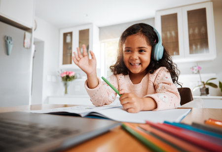 Happy little girl, laptop and elearning for education, knowledge or literature in virtual classroom at home. Female person, child or kid with smile and waving for online lesson on computer in houseの写真素材