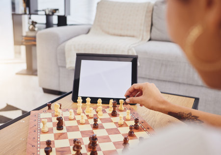 Video call, chess and woman with tablet, mockup and screen in gaming connection in living room. Thinking, internet and chessboard, virtual strategy board game and African girl problem solving in homeの写真素材